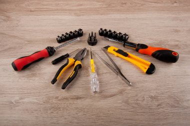 Tamir ekipmanları ahşap masada duruyordu: tornavida, cımbız, bıçak ve pense..