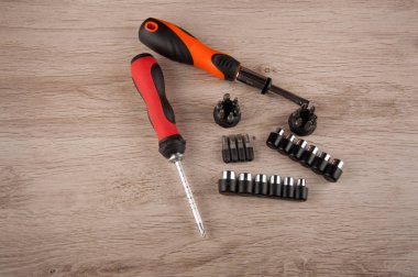 Aksesuarlar tamir ediliyor: tornavidalar ve vidalar ahşap masa üzerinde yatıyordu