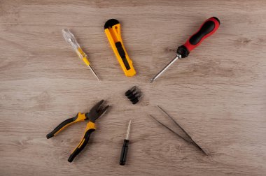 Aletleri tamir ediyorum. Tahta masanın üzerinde tornavida, pense, bıçak, cımbız ve vida vardı.