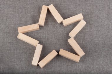 Gri kumaş arka plan üzerinde yıldız şeklinde ahşap tuğla lay