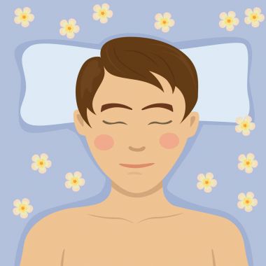 Masaj masasında yalan spa salonda rahatlatıcı çiçek tedavi olan bir genç adam. Üstten Görünüm