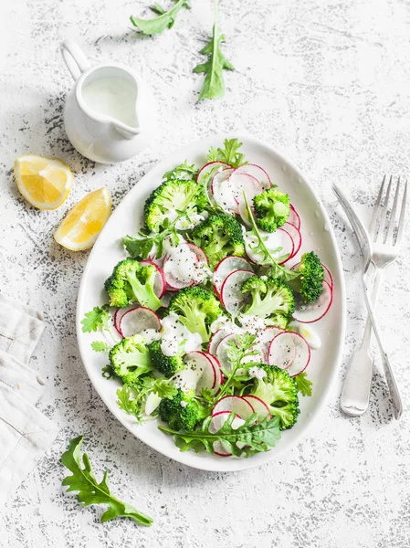 Broccoli, radish, greek yogurt salad sauce on light background, top view. Paleo diet weight loss slimming vegetarian food concept