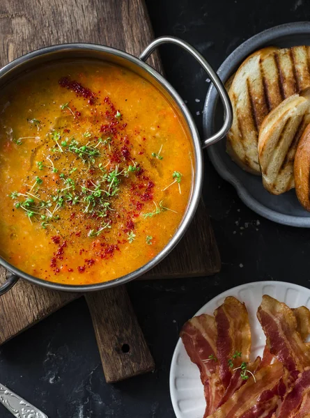 Smoked paprika lentil soup with grilled cheese sandwiches and crispy bacon on a dark background, top view. Delicious comfort food concept. Flat lay — Stock Image Smoked Paprika Lentil Soup Grilled Cheese Sandwiches Crispy Bacon Dark Royalty Free Stock Photos