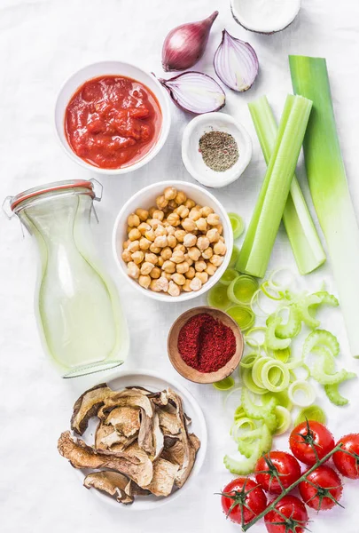 Vegetarian food ingredients for detox lunch. Soup ingredients - chicken broth, celery, leeks, lentils, chickpeas, tomatoes, red onions on a light background, top view. Flat lay — Stock Image Vegetarian Food Ingredients Detox Lunch Soup Ingredients Chicken Broth Celery Stock Photo