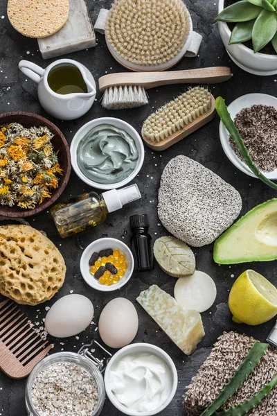 Face, body skin care homemade ingredients - cosmetic clay, brushes, homemade soap, coffee scrub, avocado, lemon, aloe, homemade oatmeal soap, calendula, chamomile dried flowers, natural yogurt on a dark background, top view. Beauty, healthy lifestyle — Stock Image Face Body Skin Care Homemade Ingredients Cosmetic Clay Brushes Homemade Stock Picture