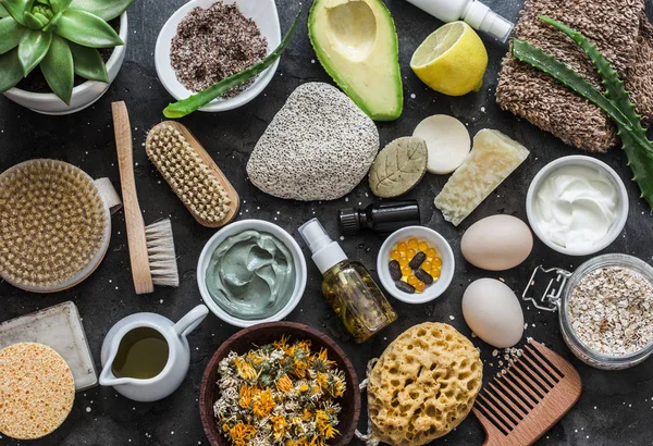 Face, body skin care homemade ingredients - cosmetic clay, brushes, homemade soap, coffee scrub, avocado, lemon, aloe, homemade oatmeal soap, calendula, chamomile dried flowers, natural yogurt on a dark background, top view. Beauty, healthy lifestyle — Stock Image Face Body Skin Care Homemade Ingredients Cosmetic Clay Brushes Homemade Royalty Free Stock Images