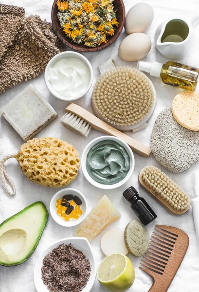Face, body skin care homemade ingredients - cosmetic clay, brushes, homemade soap, coffee scrub, avocado, lemon, homemade oatmeal soap, calendula, chamomile dried flowers, natural yogurt on a white background, top view. Beauty, healthy lifestyle conc — Stock Image Face Body Skin Care Homemade Ingredients Cosmetic Clay Brushes Homemade Stock Image
