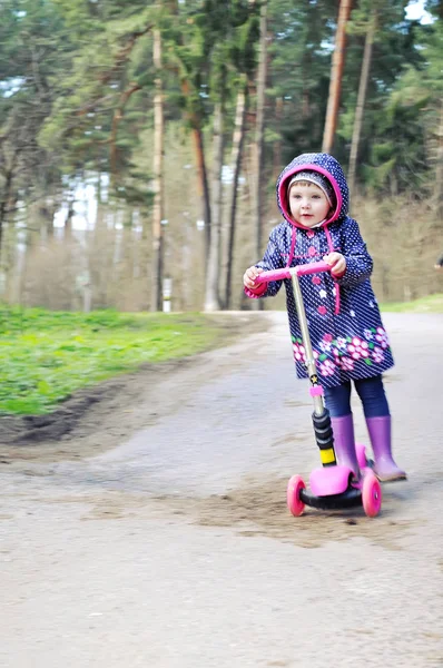 Pembe bir scooter sürme içinde küçük kız — Stok fotoğraf