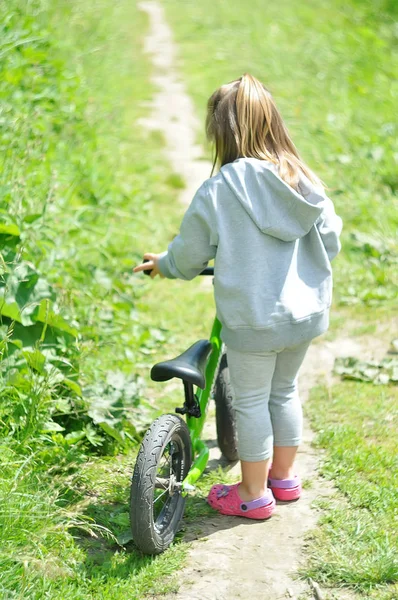 Niño linda niña montar en bicicleta en el bosque — Foto de Stock