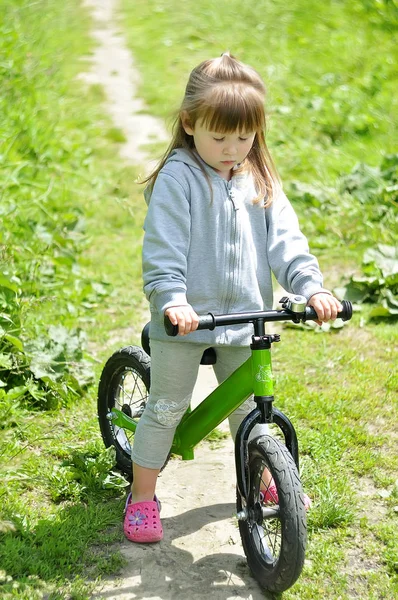 Kind süße kleine Mädchen Fahrrad fahren im Wald — Stockfoto