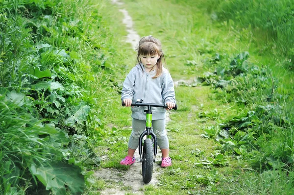 Kind süße kleine Mädchen Fahrrad fahren im Wald — Stockfoto