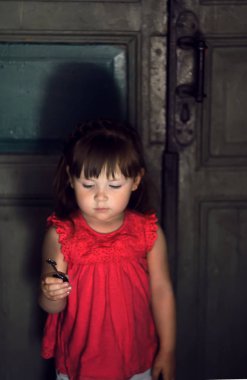 Küçük kız onun elinde, seçici odak üstünde belgili tanımlık anahtar bir anahtar tutar