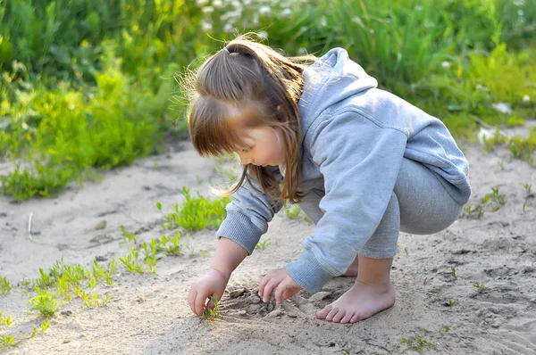 Linda niña está jugando con arena en el bosque — Foto de Stock