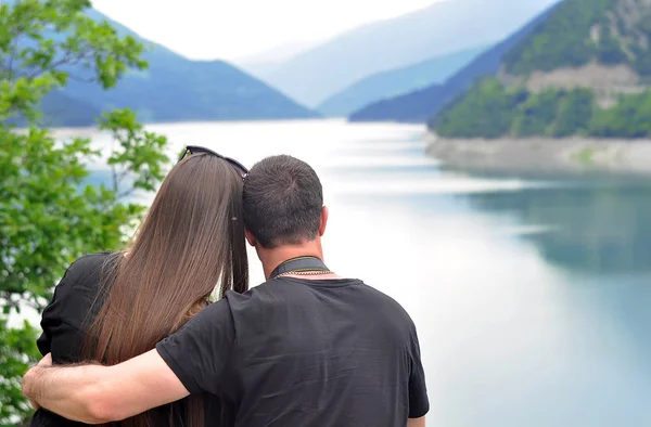 Honeymoon couple romantic in love at mountains looking on the lake during travel.