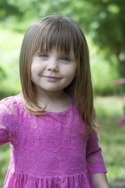 Sevimli küçük kız ormanda pembe elbiseli. Orman perisi. Güneşli gün