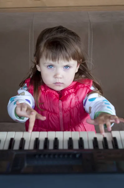 Kleines Mädchen, das Klavierspielen lernt. Konzept von Musikstudium und kreativem Hobby — Stockfoto