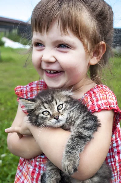 Außenporträt eines niedlichen kleinen Mädchens mit kleinen Kätzchen, Mädchen spielt mit Katze auf natürlichem Hintergrund — Stockfoto