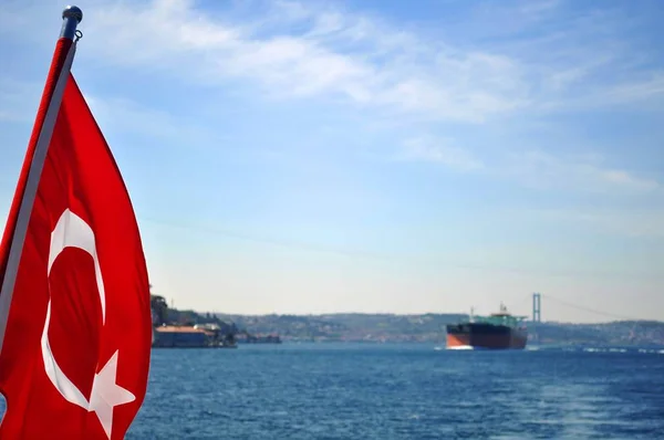 Ferries flotan en la vía navegable del Bósforo con bandera turca en primer plano —  Fotos de Stock