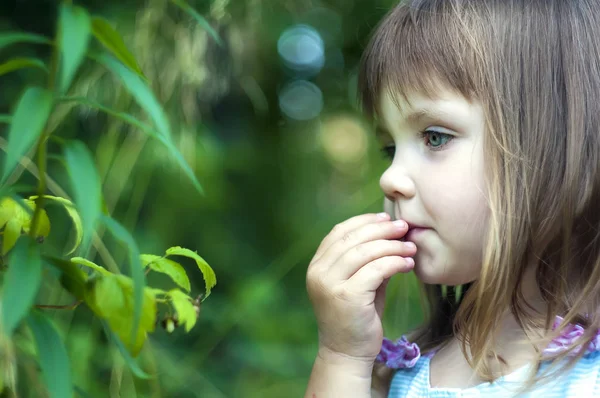 Entzückendes kleines Mädchen in weißem Kleid im Wald, das Beeren isst. Waldnymphe. sonniger Tag — Stockfoto