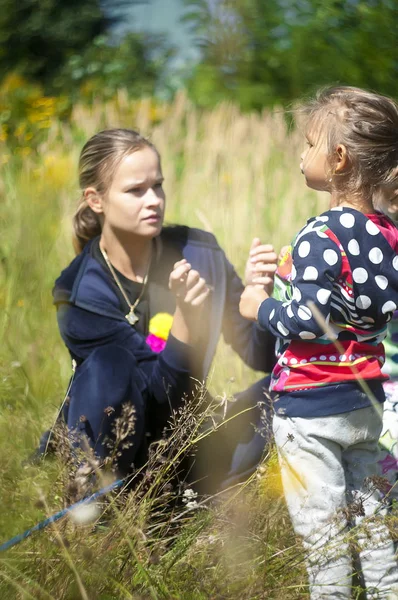 Девушка в красивом парке, с сеткой ловит бабочек, улыбается и смеется, игривое настроение, детские розыгрыши — стоковое фото
