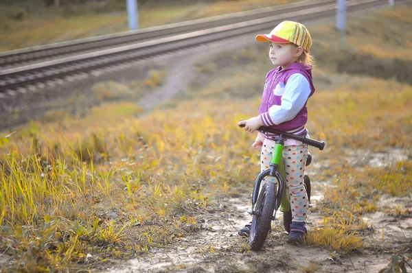 Bir tren izlerken bisikleti ile küçük kız — Stok fotoğraf