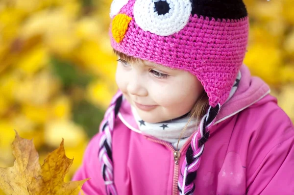 Krásné šťastné miminko dívka baví v podzimním parku, mezi spadané listí — Stock fotografie