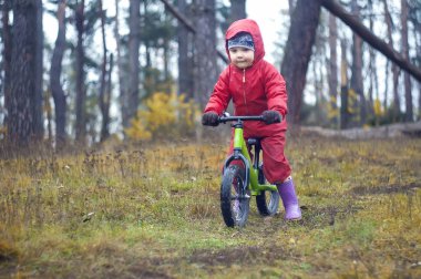 sevimli küçük kız runbike ormanda sürme