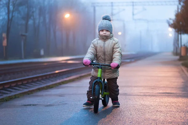Sevimli küçük kız runbike yakınındaki tren ile — Stok fotoğraf