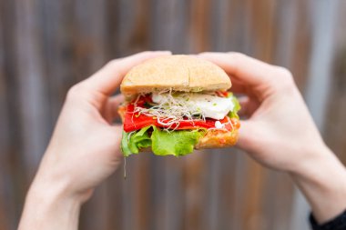 El ele tutuşup sandviç yiyen kız.