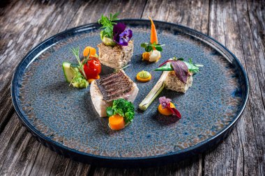 Pişmiş sebzeler ve patates turtasıyla ızgara levrek fileto.