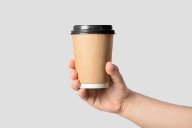 Açık gri arka planda izole edilmiş kahve fincanı tutan erkek eli.. 