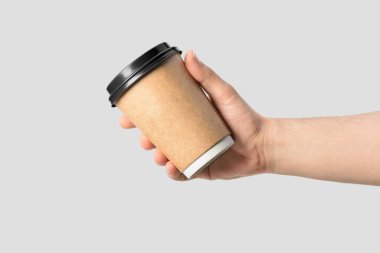 Açık gri arka planda izole edilmiş kahve fincanı tutan erkek eli.. 