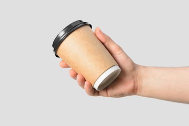 Açık gri arka planda izole edilmiş kahve fincanı tutan erkek eli.. 