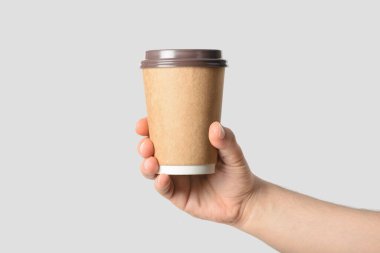 Açık gri arka planda izole edilmiş kahve fincanı tutan erkek eli.. 