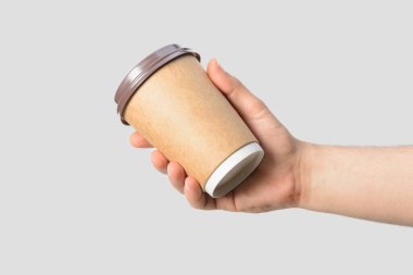 Açık gri arka planda izole edilmiş kahve fincanı tutan erkek eli.. 