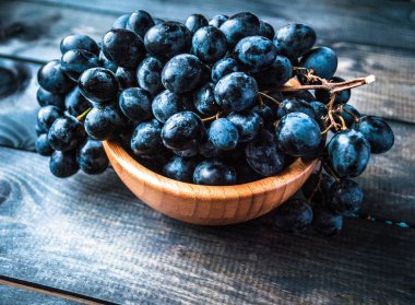 Bambu kasesinde bir demet siyah üzüm.