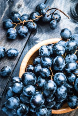Bambu kasesinde bir demet siyah üzüm. Üst görünüm
