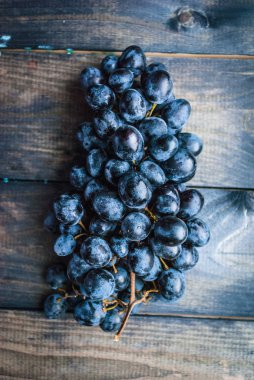 Ahşap bir arka planda bir demet siyah üzüm. Üst görünüm