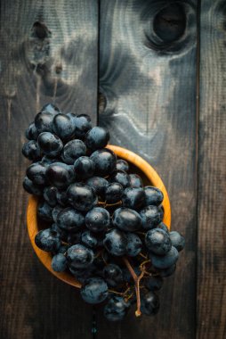Bambu kasesinde bir demet siyah üzüm. Kırsal arkaplan