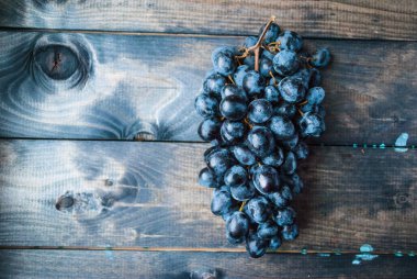 Ahşap bir arka planda bir demet siyah üzüm. Kopyalama alanı