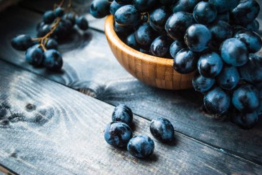 Eski püskü bir arka planda bir demet siyah üzüm. Kapat.