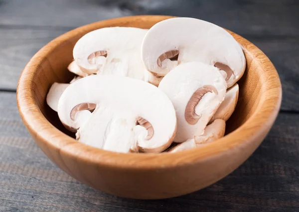 Sliced raw white champignons preparing for cooking