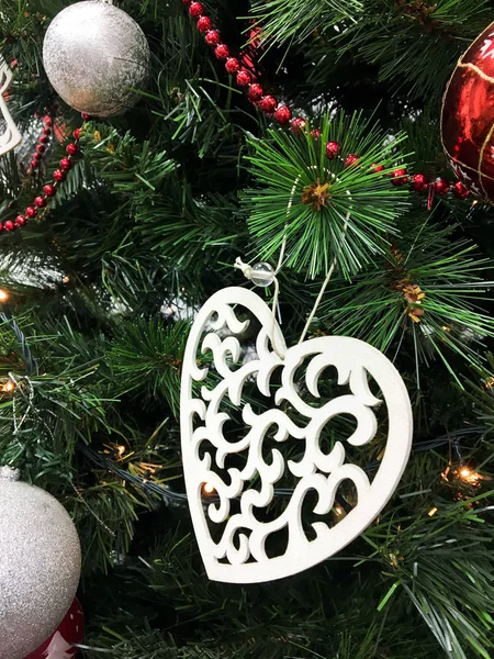 Herz spielzeug dekoration auf einem weihnachtsbaum grünen zweig — Stockfoto
