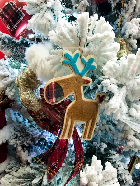 Hirsch-Spielzeugdekoration auf einem Weihnachtsbaumzweig mit Kunstschnee — Stockfoto