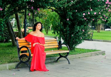 parkta bir bankta oturan genç kadın