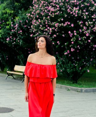 Pembe çiçekler yakınındaki güzel bir esmer kadın portresi