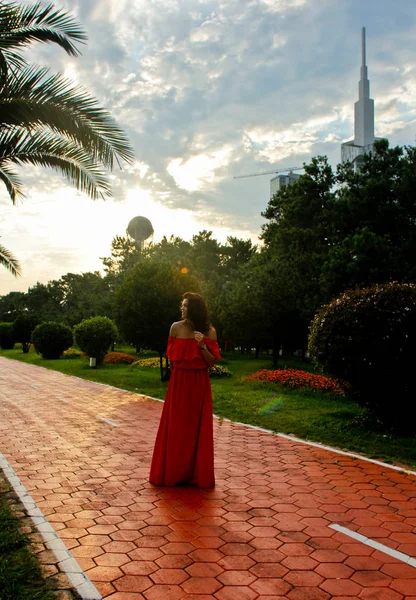 Hermosa mujer en vestido rojo de verano contra las palmas —  Fotos de Stock