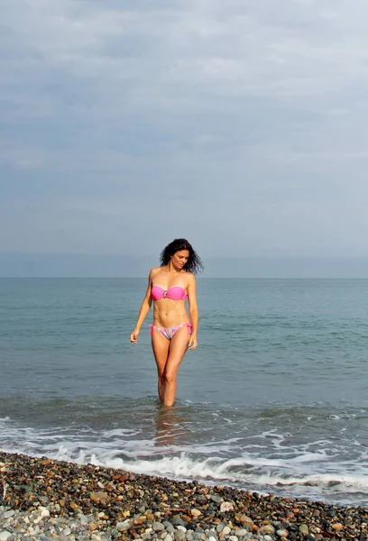 Ritratto di bella donna in bikini rosa sullo sfondo del mare — Foto Stock