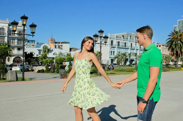 Romantik mutlu kadın ve erkek sokakta dans ediyor. Genç bir çift açık deniz limanı yakınlarında yürüyor, Batumi Georgia..