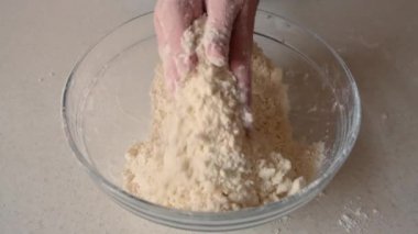 Kadınların elleri tereyağı ve unu cam bir kaseye sürer. Ev yapımı pişirme ve şekerleme..